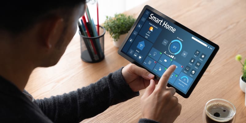 An Indian person using a mobile app to manage smart home devices, illustrating the benefits of smart home technology for Indian households.