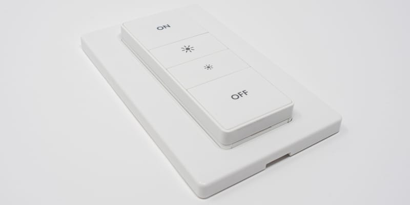 Man adjusting smart lighting through mobile app at home, showcasing smart lighting technology for better health, safety, and energy efficiency.